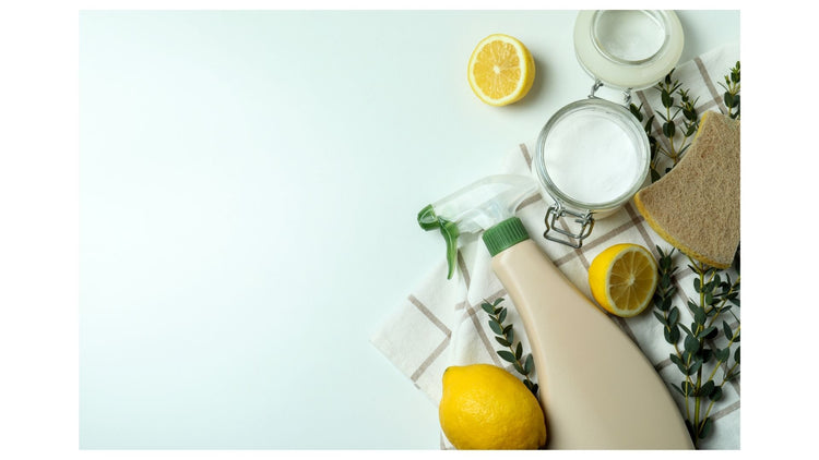Cleaning products with lemons and a sponge on a light blue background